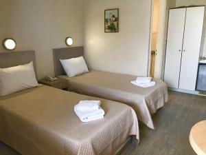 two beds in a hotel room with towels on them at Sailor's Nautical Concept in Spetses