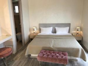 a bedroom with a large bed with a red ottoman at Sailor's Nautical Concept in Spetses