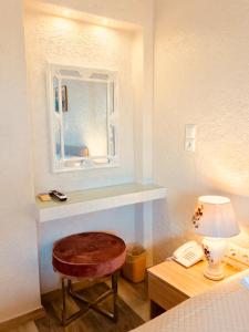 a room with a table and a stool and a mirror at Sailor's Nautical Concept in Spetses