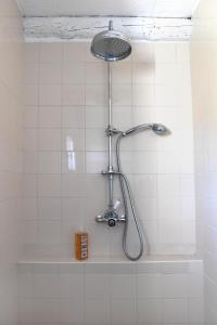 eine Dusche in einem weiß gefliesten Bad in der Unterkunft La Maison De Bécaras in Bédoin