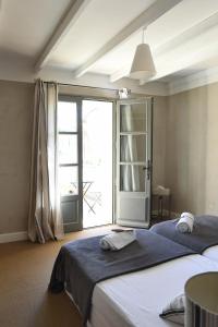 2 Betten in einem Zimmer mit einem großen Fenster in der Unterkunft La Maison De Bécaras in Bédoin