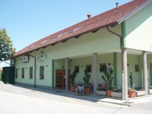 a green building with potted plants in front of it at Motel Divjak in Spodnje Hoče