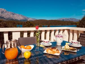 a table with a breakfast of orange juice and croissants at Apartments Daniela in Korčula