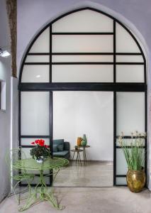 an arched glass door in a room with a table at Acre Two Wells Zimmer in Acre