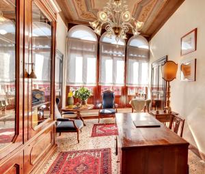 Habitación decorada con mesa, sillas y lámpara de araña. en Palazzo Schiavoni Residenza d'epoca & Suite-Apartments en Venecia