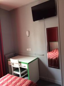 a bedroom with a desk and a mirror and a bed at Hotel Les Arcades in Rouen