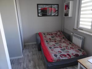 een kleine slaapkamer met een bed met een deken bij Zenhouse apartament Warszawa Ursynów, Mokotów wynajem krótkoterminowy, noclegi in Warschau