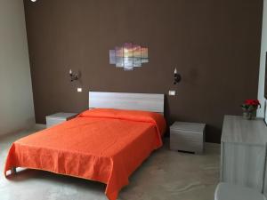 モンテローニ・ディ・レッチェにあるZeroSalento Casa Vacanzeのベッドルーム1室(オレンジ色のベッドカバー付)