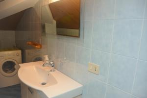 La salle de bains est pourvue d'un lavabo et d'un lave-linge. dans l'établissement Mansarda Natalie, à Levanto