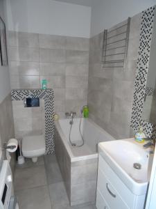 ein Badezimmer mit einer Badewanne, einem WC und einem Waschbecken in der Unterkunft Zenhouse apartament Warszawa Ursynów, Mokotów wynajem krótkoterminowy, noclegi in Warschau