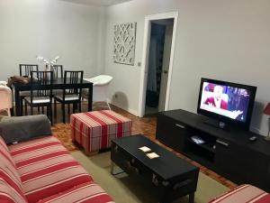 a living room with a couch and a tv at Lauramer Apartamento Bakio in Bakio
