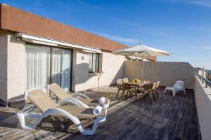 een balkon met een tafel en stoelen en een parasol bij Apartaments Cye Salou in Salou