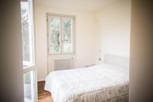 貝拉焦的住宿－Maison Casa Lavanda，一间白色卧室,配有床和2个窗户