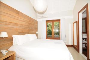 a bedroom with a white bed and a window at Rio Búzios Boutique Hotel in Búzios