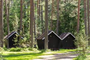 two black structures in a forest with trees at Kauksi Campsite in Kauksi