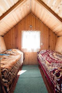 two beds in a room with a window at Kauksi Campsite in Kauksi