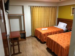 a hotel room with two beds and a mirror at Sumaq Hotel Tacna in Tacna