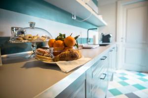 a kitchen counter with a bowl of oranges and bread at B&B Villa Sant'Angelo in Ginosa Marina +12 photos