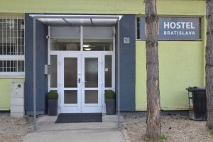 un edificio de hospital con una puerta blanca y una señal en Hostel Bratislava en Bratislava