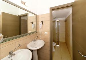La salle de bains est pourvue d'un lavabo, d'un miroir et de toilettes. dans l'établissement La Casa di Ora, à Casamassella