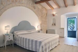 - une chambre avec un lit et un mur en pierre dans l'établissement La Casa di Ora, à Casamassella
