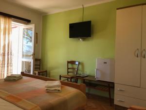 a bedroom with a bed and a tv on the wall at Summer rooms Baška in Baška