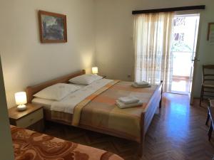 a bedroom with two beds and a sliding glass door at Summer rooms Baška in Baška