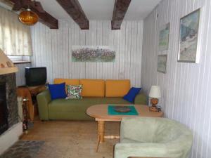 een woonkamer met een groene bank en een tafel bij Uroczy Domek Z Ogrodem I Tarasem in Myślenice