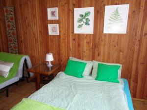 1 dormitorio con 1 cama con almohadas verdes en Uroczy Domek Z Ogrodem I Tarasem, en Myślenice