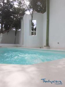 uma piscina com água azul em frente a um edifício em Thalassitra Private Pool Suites & Spa em Adamas