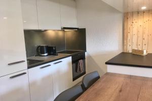 a kitchen with white cabinets and a table and chairs at Grain d'Or - Studio 008 in Verbier