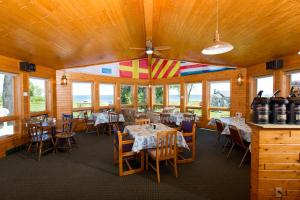 a dining room with tables and chairs and windows at Square Rigger Lodge in Jacksonport