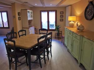 uma cozinha com uma mesa de jantar e cadeiras em La maison Céline em Bergheim