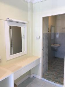 a bathroom with a sink and a shower and a mirror at Thai Orchid Guest House in Jomtien Beach