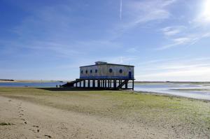 a building on the beach next to the ocean at Apartamento Ria Formosa in Fuzeta