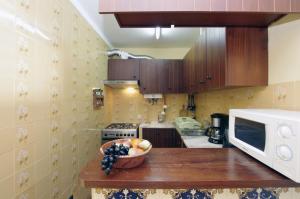 a kitchen with a bowl of fruit on a counter at Apartamento Ria Formosa in Fuzeta