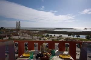 Apartamento Ria Formosa في فوزيتا: طاولة على شرفة مطلة على المحيط