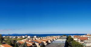una calle de la ciudad con edificios y el océano en el fondo en Attico Del Sole en Rometta Marea