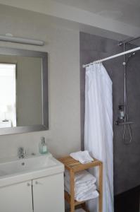 a bathroom with a shower curtain and a sink at The Old Post Office Guesthouse in Grundarfjordur