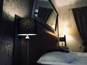 a bedroom with a bed with a mirror and a lamp at Apartament Ormiańska in Zamość