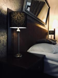 lampa na stole obok łóżka w obiekcie Apartament Ormiańska w mieście Zamość