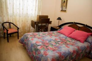 1 dormitorio con cama, silla y escritorio en Casa Rural el Cedro, en Abejar