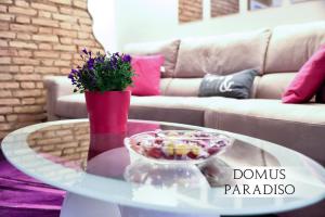 a coffee table with a bowl of candy and flowers on it at Domus Paradiso City Center in Rome