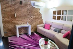 a living room with a couch and a brick wall at Domus Paradiso City Center in Rome
