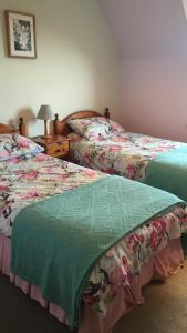 dos camas sentadas una al lado de la otra en un dormitorio en Tweed Cottage en Jedburgh