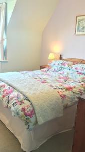 a bed with a colorful quilt on top of it at Tweed Cottage in Jedburgh