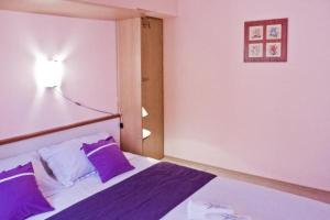 ein Schlafzimmer mit einem Bett mit lila Kissen und einer Lampe in der Unterkunft Vila Martin in Sevid