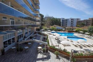a hotel with a swimming pool with lounge chairs and umbrellas at Aparthotel Cye Holiday Centre in Salou