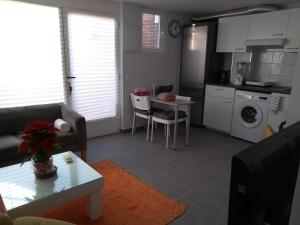 a living room with a couch and a table and a kitchen at COZY APARTAMENT 10 MINUTES FROM THE HEART OF MADRID in Madrid
