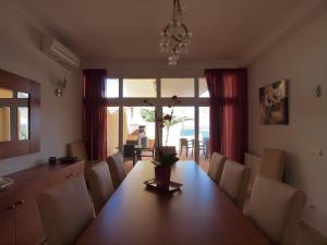 Un comedor con mesa y sillas de madera. en Cas Llop Ibiza Luxury Views, en Cala Tarida
